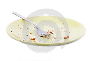 Cake crumbs and fork on yellow plate photo