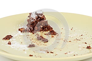 Cake crumbs leftovers on green plate on white photo