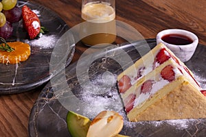 Cake and cup of coffee. Still-life with dessert and fruit and a red napkin on a light background.