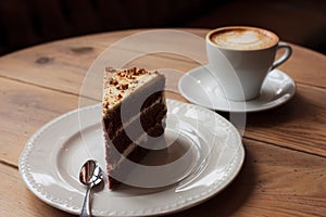 Cake and cup of coffee on a wooden desk table