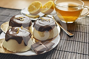 Cake with a cup of tea on a dark wooden background.Dessert of cottage cheese in chocolate glaze