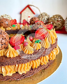 Cake decorated with dulce de leche, strawberries and brigadeiro balls. photo