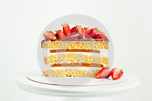 cake decorated with strawberries on the white background. Yellow sponge bisquit cake cut with cream cheese and berry mousse