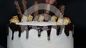 Cake decoration with sweets chocolate, cookies, waffles, kumquat, close up. Time lapse video