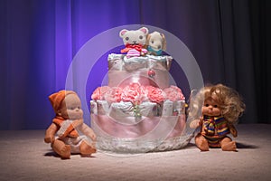 Cake of diapers, baby shower gift diaper, wrapped diapers, a roll of diapers, wrapped a clean diaper on table with baby doll decor