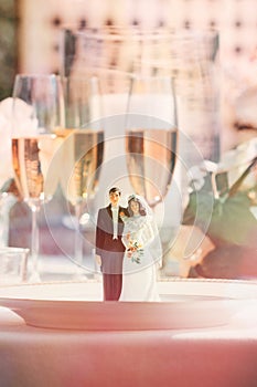 Cake figurines on dinner plate at reception