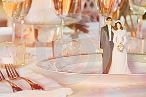 Cake figurines resting on plate at reception