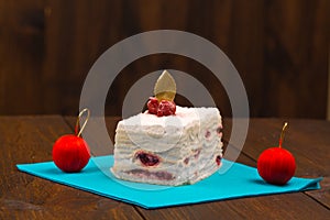Cake with fresh cherry on wooden background