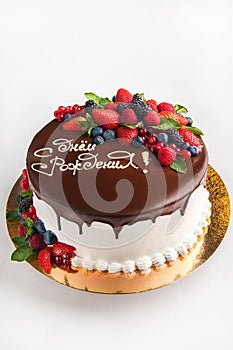 Cake with fruit, chocolate, flowers is isolated on a white background close-up and copy space. In Russian the inscription `Happy B