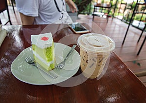 Cake and Ice coffee are on the wood table