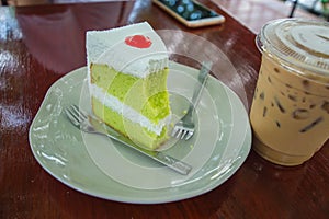 Cake and Ice coffee are on the wood table