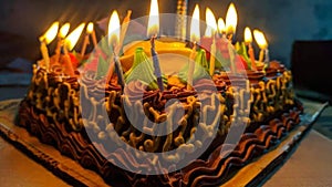 A cake with lit candles. Birthday cake with candles lit up and balloons on the background. Children sitting in front of birthday