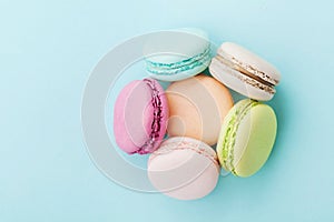 Cake macaron or macaroon on turquoise background from above, almond cookies, pastel colors