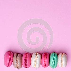 Cake macaron or macaroon on turquoise background from above, colorful almond cookies, pastel colors, vintage card, top