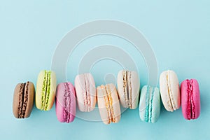 Cake macaron or macaroon on turquoise background from above, colorful almond cookies, top view