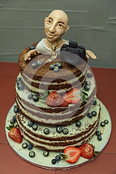 A cake with a model of a marcipan photographer photo