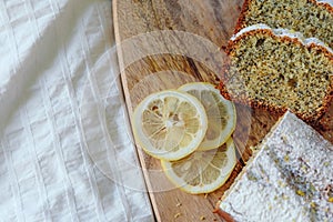 Cake with poppy seeds and lemon zest, sprinkled with powdered sugar. Cupcake with lemon on a wooden board.