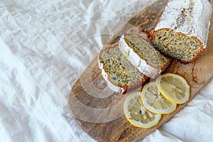 Cake with poppy seeds and lemon zest, sprinkled with powdered sugar. Cupcake with lemon on a wooden board.