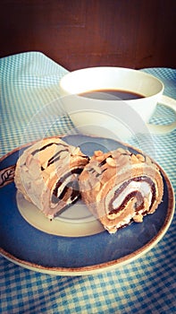 Cake roll with cup of coffee