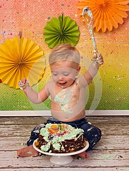 Cake smash boy waving with spoon