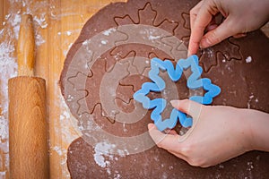 Cake spread on a countertop with starred hands, hands hold the form, the rolling pin lies on the edge