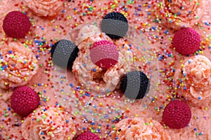 Cake with strawberries, blackberries and colorful sprinkles on the green plate and colorful strawberry