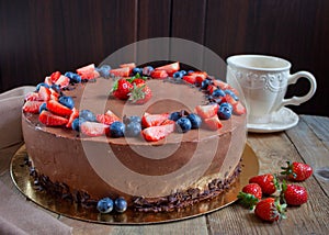 Cake Three chocolate with fresh berries and cup of tea