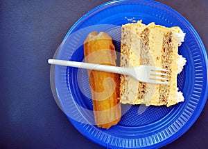 cake and  turkish sweet Tulumba dessert in a blue disposable plate top view