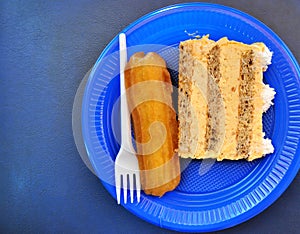 cake and  turkuish sweet Tulumba dessert in a blue disposable plate top view