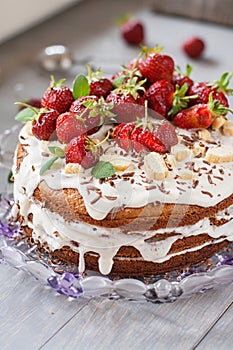 Cake with white cream decorated by strawberries