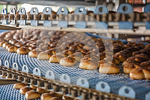 Cakes on automated round conveyor machine in bakery food factory, production line