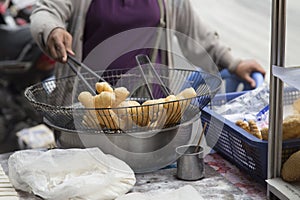 Cakes in a colander atop a street stall in Phnom Penh