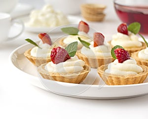 Cakes, cupcakes with fresh fruits (strawberries), whipped cream and mints