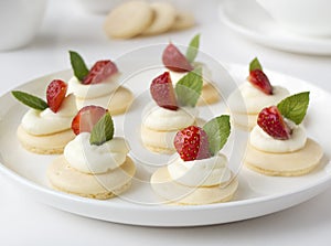 Cakes, cupcakes with fresh fruits (strawberries), whipped cream and mints