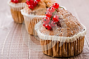 Cakes decorated with red currant berries/cakes decorated with red currant berries on a wooden background. copy space
