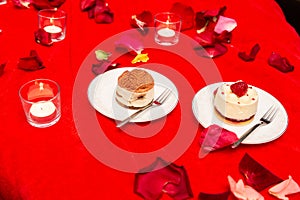 Cakes in white plates on a red tablecloth