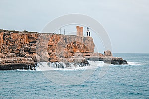 Cala Figuera - rough coastline and view of old lighthouse in Cala Figuera, Mallorca, Spain