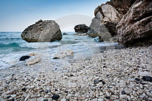 Cala Gonone empty beach in Sardinia with rocks and waves on an o