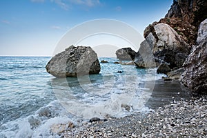 Cala Gonone empty beach in Sardinia with rocks and waves on an o