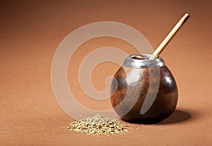 Calabash and bombilla with yerba mate isolated on brown