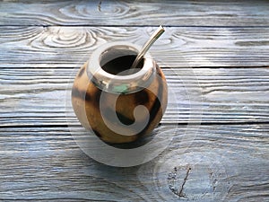 Calabash and mate bombilla on wooden background