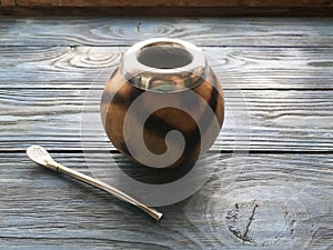 Calabash and mate bombilla on wooden background