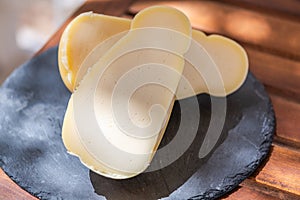 Calabrian cheese caciocavallo silano on cutting ardesian board on the table