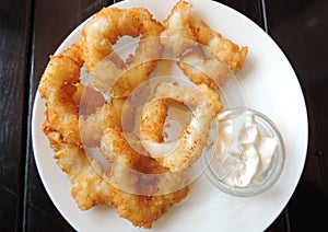 Calamares a la romana, fried battered squid rings   with sauce on an old table photo
