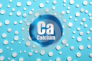 Calcium supplement pills on turquoise background, flat lay