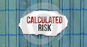 Calculated risk text on the piece of paper on the green wood background