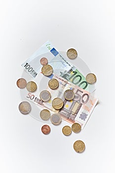 Calculation of expenses. 100 and 50 Euro banknotes with coins. Top view.