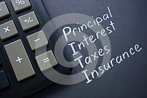 Calculator and abbreviation PITI Principal interest taxes insurance. photo