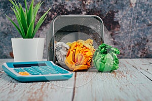 Calculator with artificial plant and crumple paper on the table for business and copy space