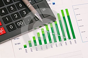 Calculator, chart and pen close up. Stock market analysis. Financial and accounting reporting. Business concept